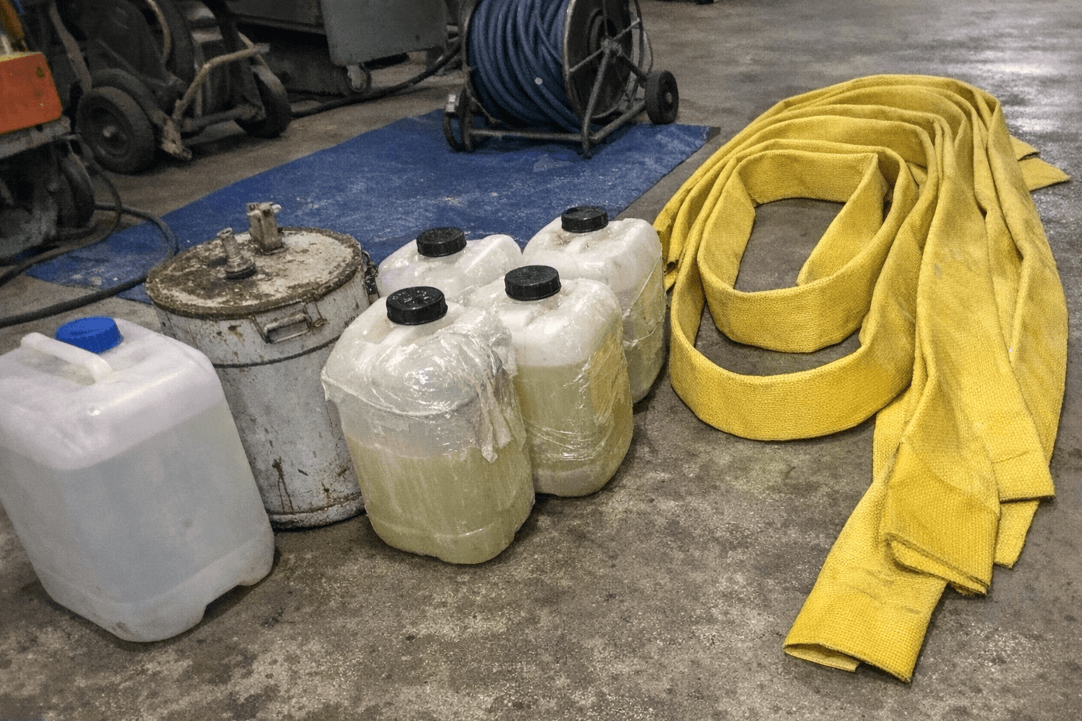 Vorbereitete Harzkomponenten und ein textiler Schlauch auf einer Werkbank